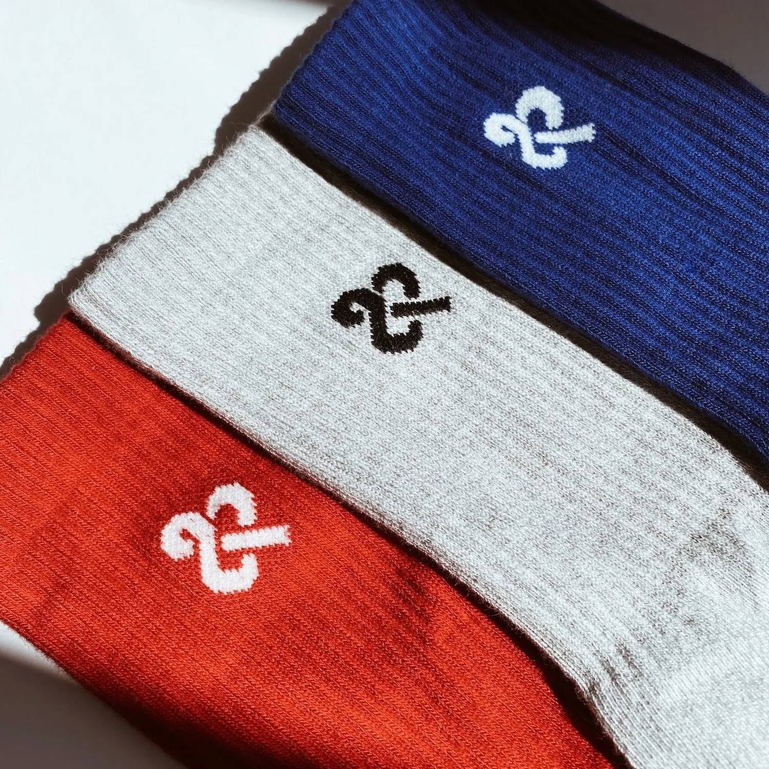 And Beyond crew socks in cobalt, grey and red under warm natural light